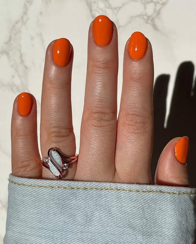 11. Glossy Short Oval Nails in Classic Bright Orange - bright orange nail ideas
