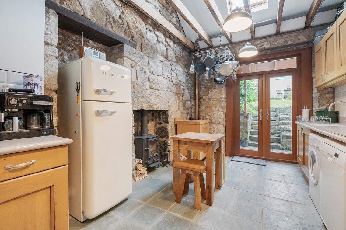 16. Rustic Stone Cottage Kitchen with Cream Accents - unique kitchen ideas