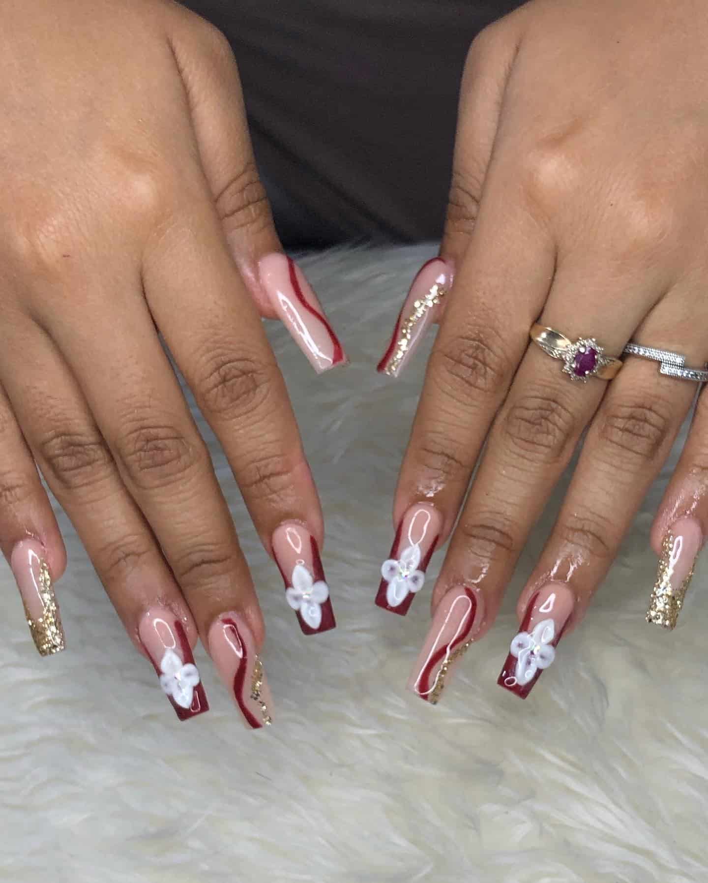 2. Burgundy French Tip Coffin Nails with White Florals & Gold Glitter - burgundy and gold nail ideas