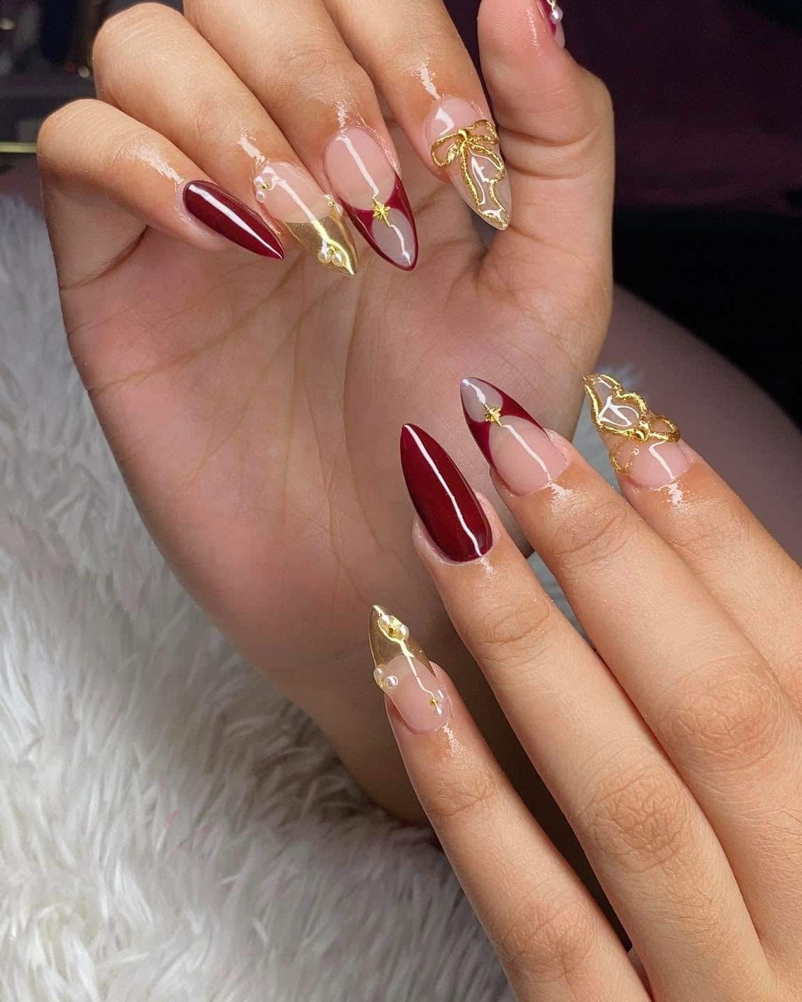 22. Burgundy and Gold Stiletto Nails with 3D Bow and Metallic French Details - burgundy and gold nail ideas