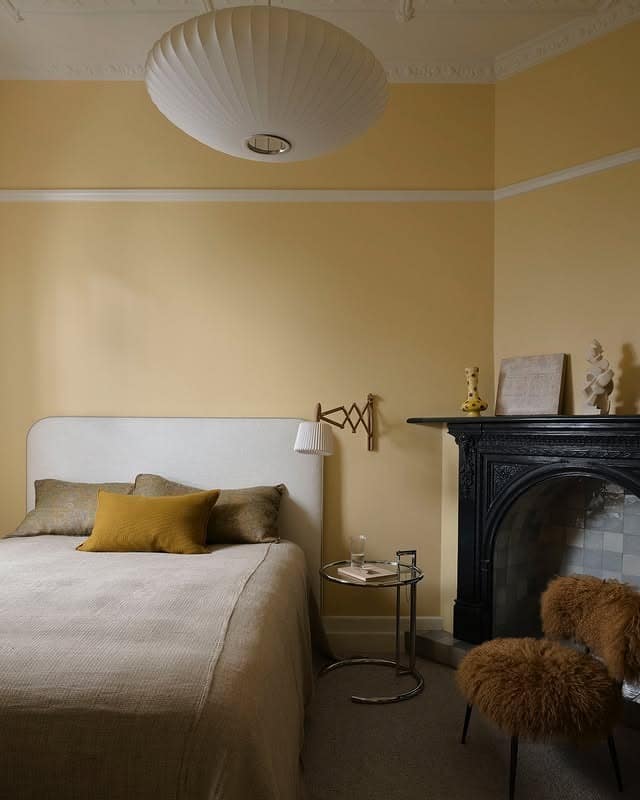 20. Classic Fireplace Bedroom in Creamy Buttermilk Yellow - yellow bedroom ideas