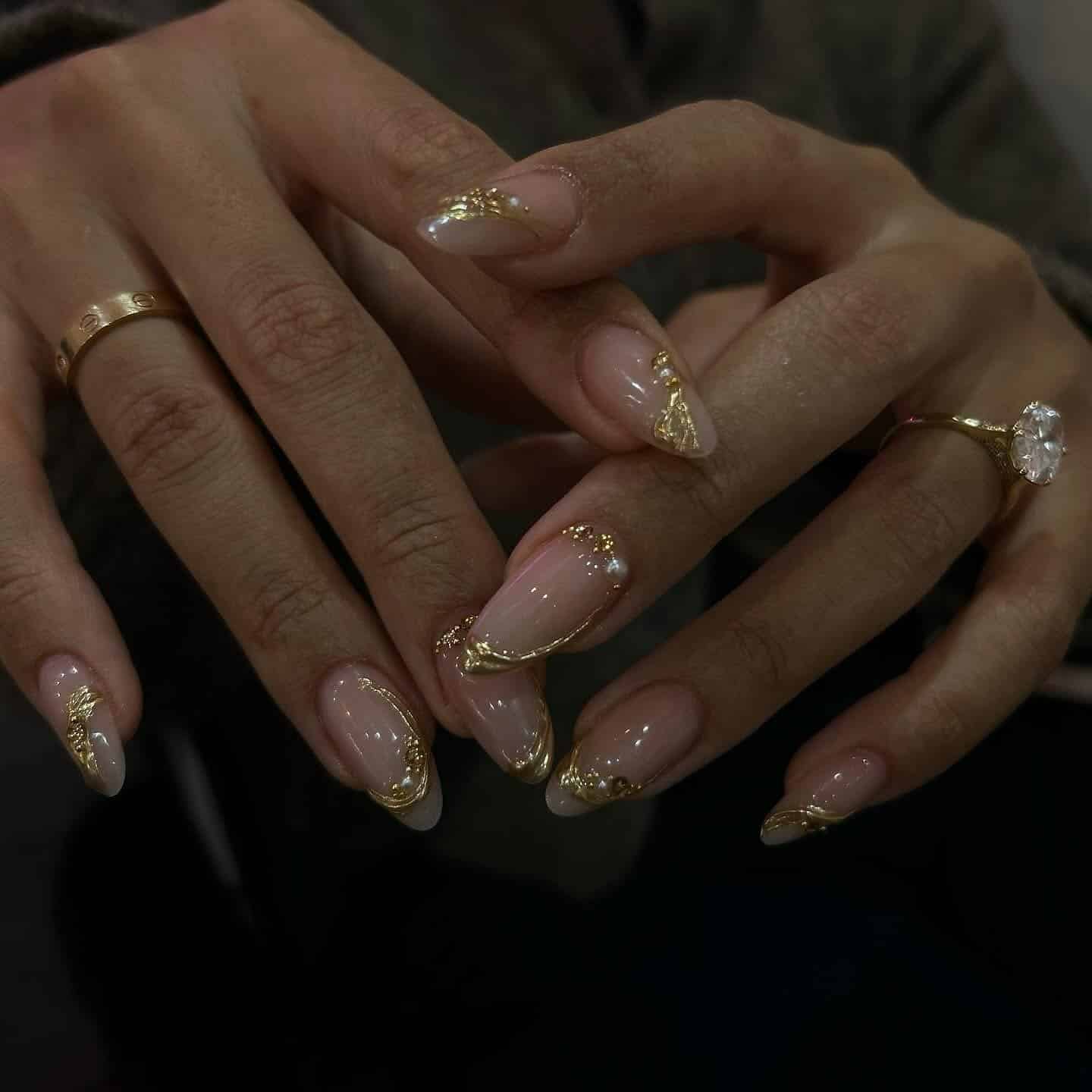 17. Nude Almond with Sculpted Gold Embellishments - classy almond nail ideas