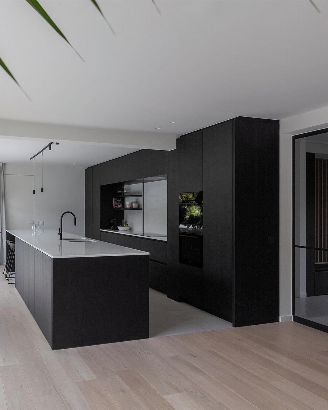 7. Minimalist Black and White Kitchen with Statement Island - black kitchen cabinets ideas