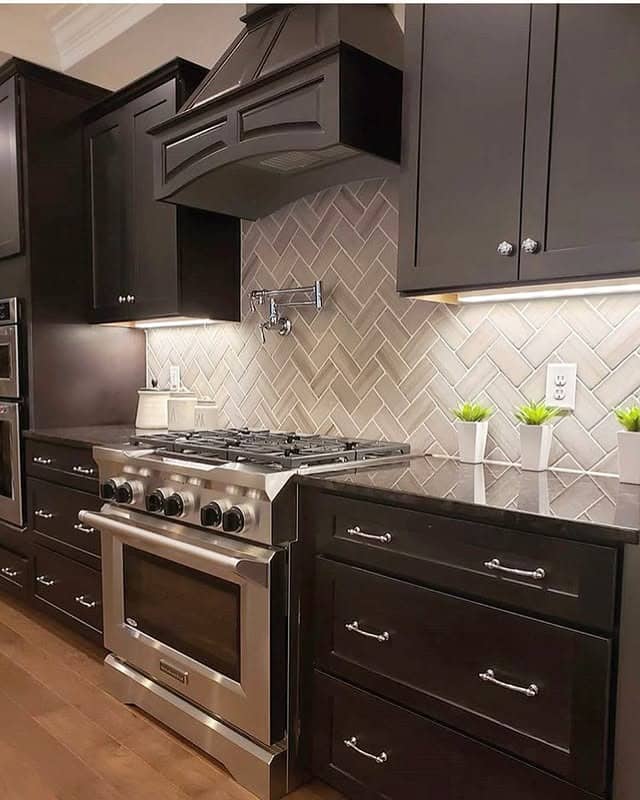 17. Chocolate Brown Cabinets with Herringbone Tile Backsplash - dark kitchen cabinet ideas
