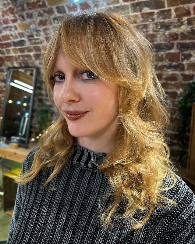 22. Golden Blonde Feathered Shag with Soft Full Bangs - Medium Length Shag Hairstyles