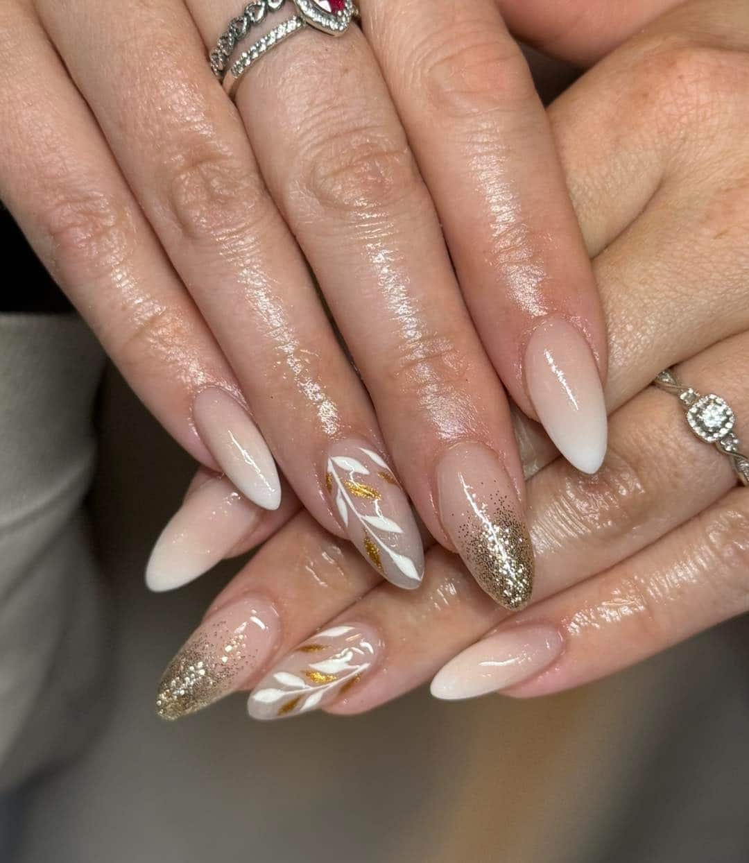 6. Nude Almond Nails with Gold Glitter Gradient and Leaf Art - elegant bridal nail ideas