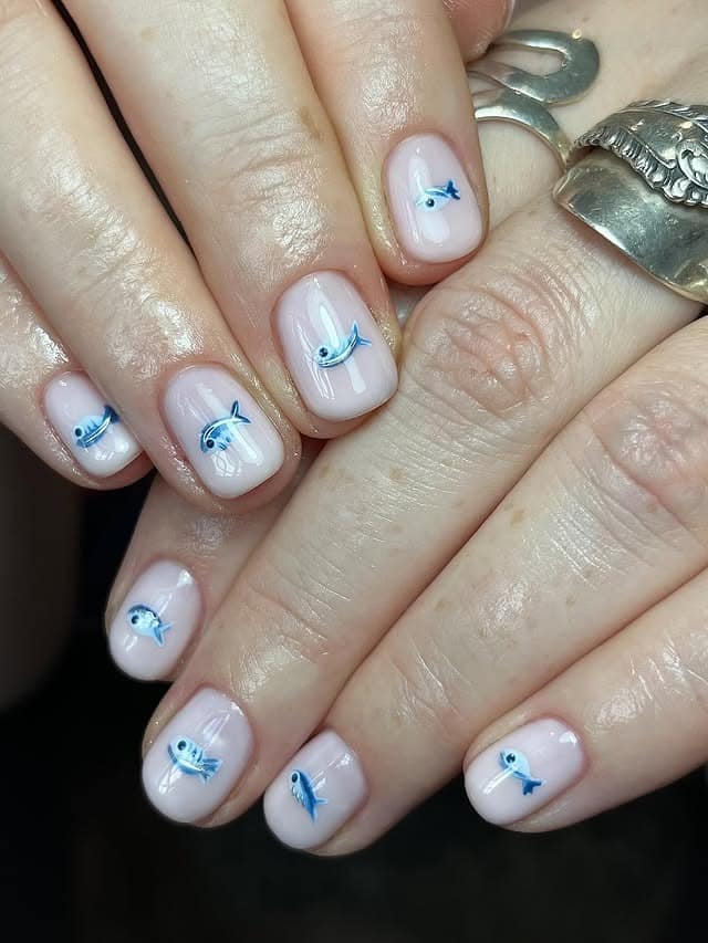 17. Sheer Pink Short Nails with Tiny Blue Fish - fish nail ideas
