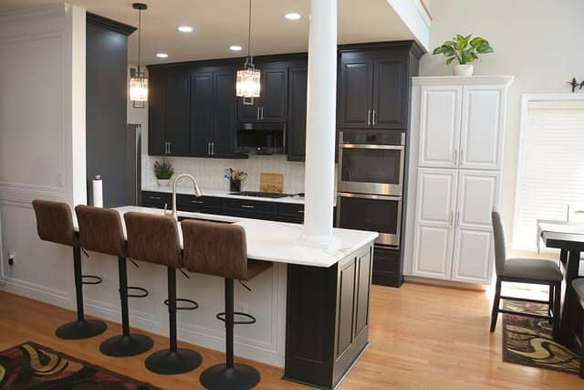 3. Black and White Contrast Kitchen with Warm Wood Floors - black cabinets kitchen ideas