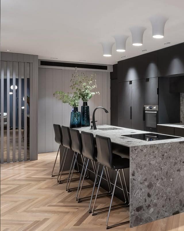 9. Contemporary Black Kitchen with Stone Waterfall Island - black cabinets kitchen ideas