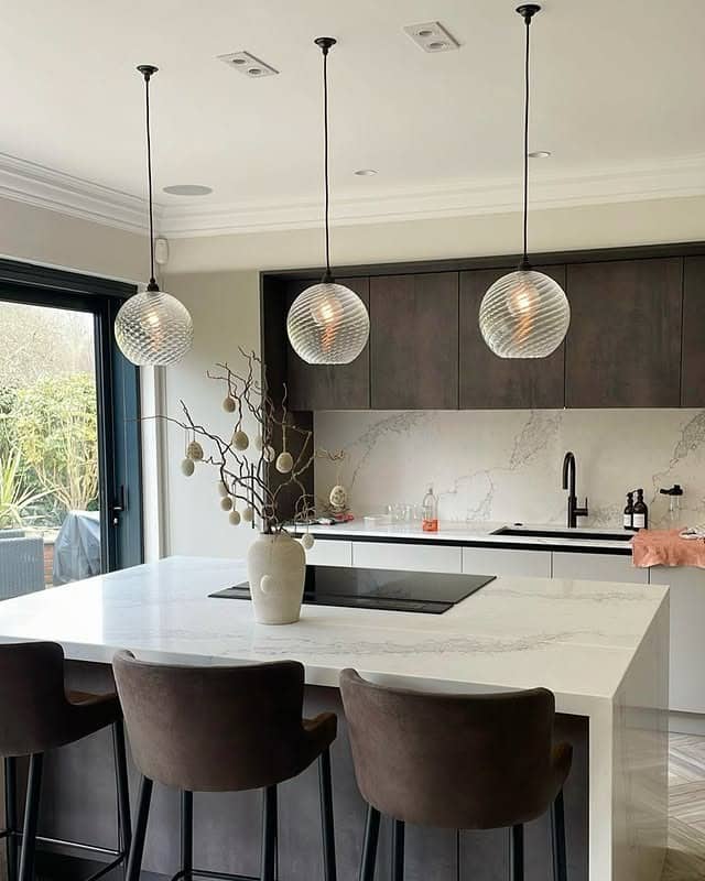7. Two-Tone Brown Cabinets with Sculptural Pendant Lighting - brown kitchen cabinets ideas