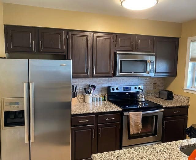 10. Dark Brown Raised-Panel Cabinets with Granite Counters - brown kitchen cabinets ideas