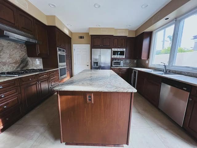 10. Rich Espresso Garage Kitchen with Oversized Island - garage kitchen ideas