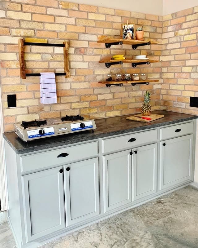 18. Industrial Garage Kitchen with Exposed Brick and Soft Gray Cabinets - garage kitchen ideas