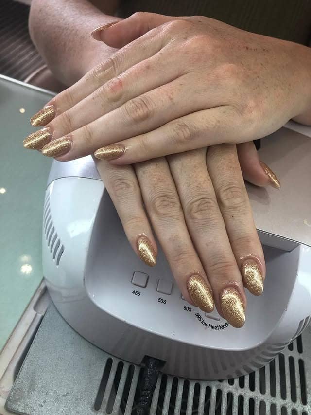 6. Warm Chestnut Hair with Full Gold Shimmer Almond Nails - gold glitter nail ideas
