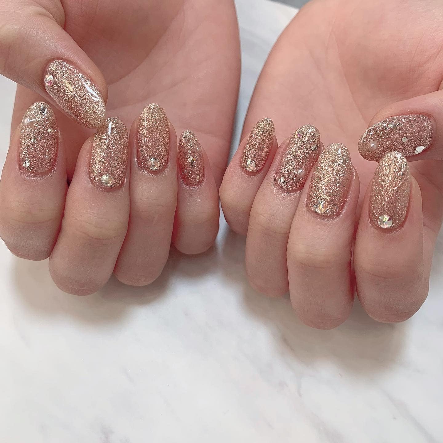 22. Champagne Blonde Soft Waves with Crystal-Embellished Gold Glitter Almond Nails - gold glitter nail ideas