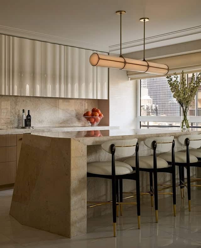 11. Sculptural Beige Kitchen with Fluted Cabinetry and Stone Island - beige kitchen ideas