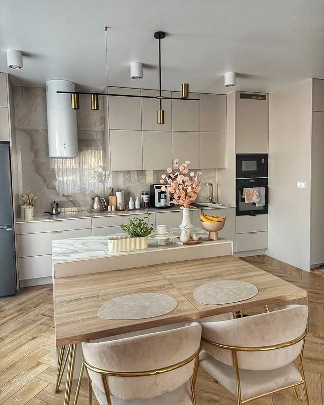 13. Modern Beige Kitchen with Brass Linear Lighting and Marble Accents - beige kitchen ideas