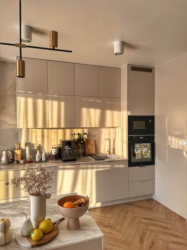 17. Sunlit Beige Kitchen with Glossy Cabinets and Herringbone Floors - beige kitchen ideas
