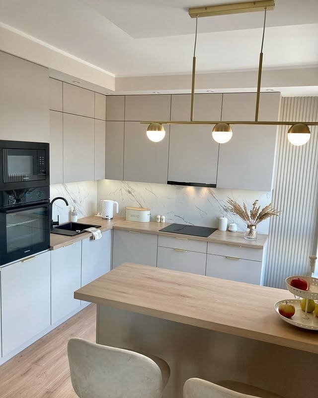18. Soft Beige L-Shaped Kitchen with Brass Pendant Trio - beige kitchen ideas
