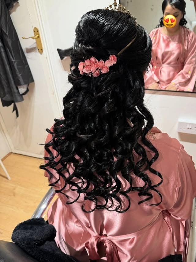 3. Glossy Black Half-Up Curls with Floral Accent - Birthday Hairstyles