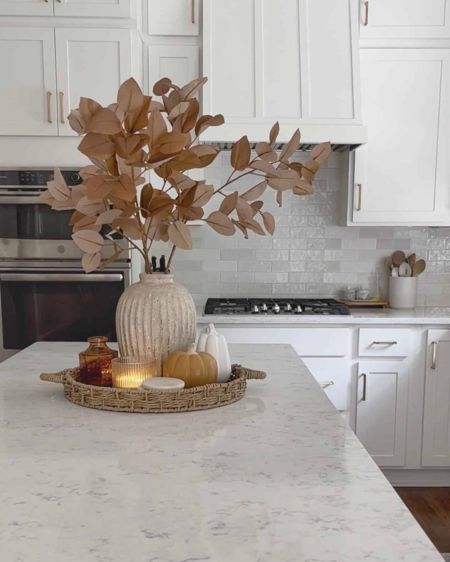 21. Neutral White Kitchen with Caramel Leaf Centerpiece - fall kitchen decor ideas