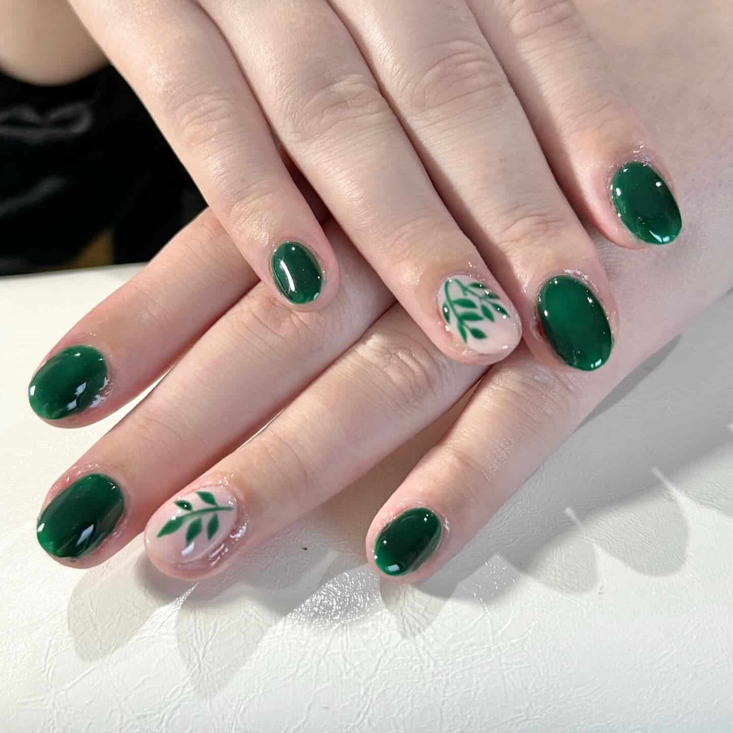 15. Deep Emerald Short Oval Nails with Simple Leaf Accent - leaves nail ideas