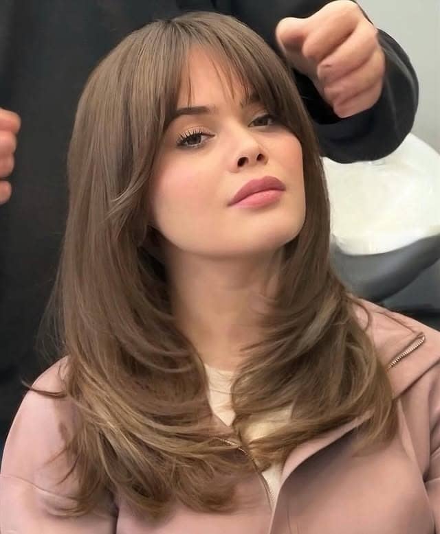 1. Feathered Medium Layers with Soft Chestnut Bangs - Medium Haircuts With Bangs