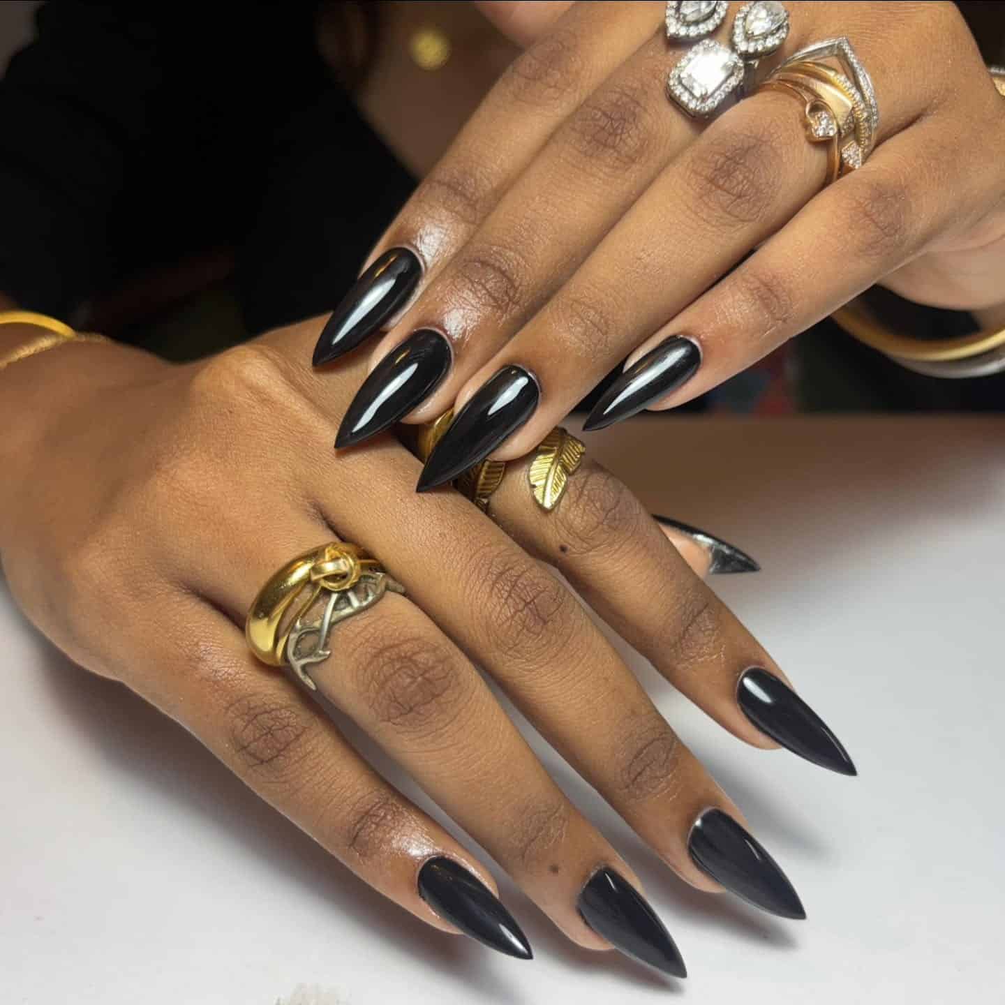 11. Glossy Black Almond Stiletto Nails - long black nail ideas