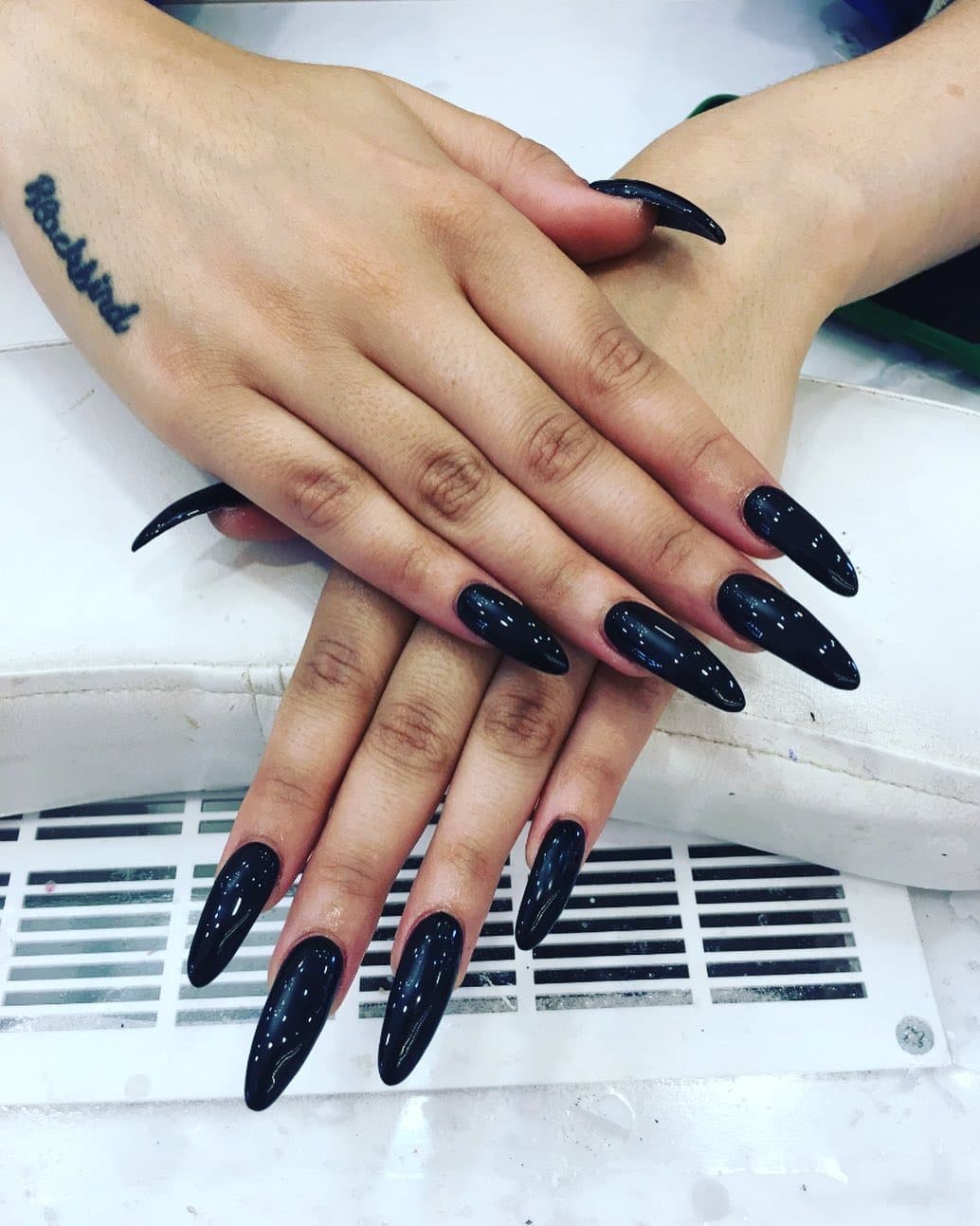 21. Glossy Black Long Almond Nails - long black nail ideas