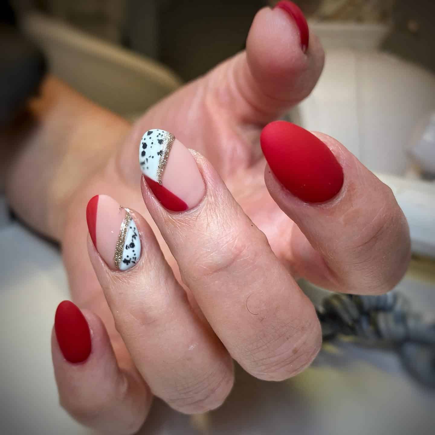 19. Matte Red Almond Nails with Gold Glitter and Speckled Accent - matte red nail ideas