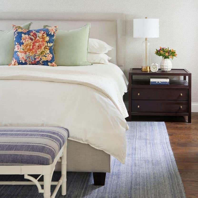 11. Soft Cream Bedroom with Floral Accent Pillow - serene bedroom ideas