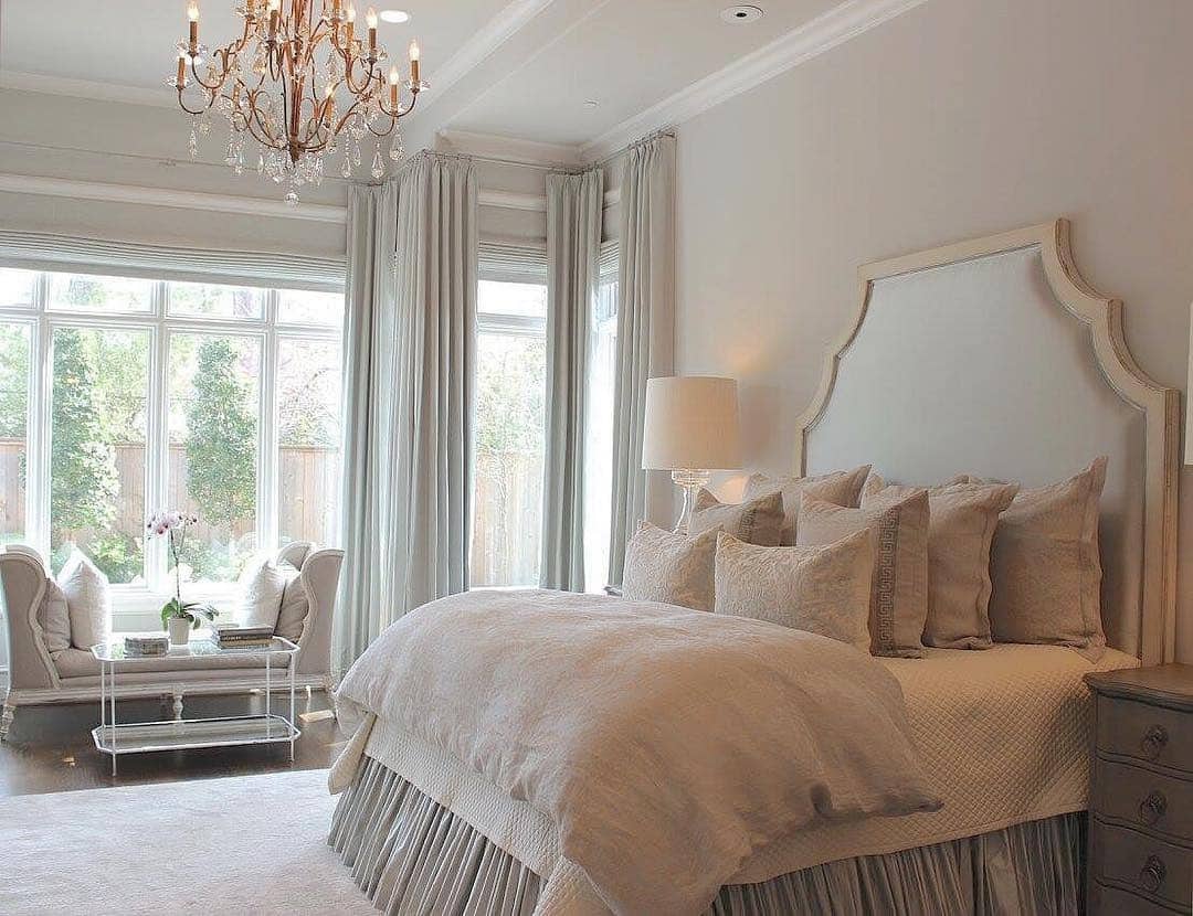 20. Elegant Cream Bedroom with Statement Chandelier and Tall Windows - serene bedroom ideas