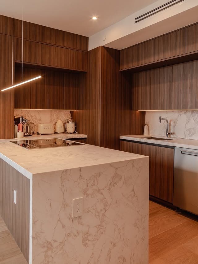 4. Contemporary Wood Kitchen with Marble Waterfall Island - brown kitchen ideas