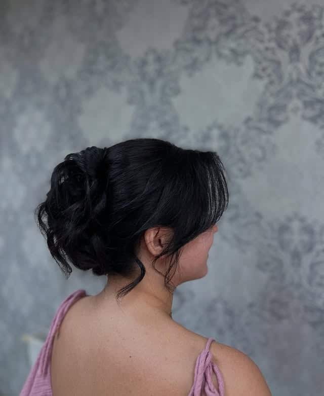 3. Soft Black Textured Low Bun with Curtain Fringe - Elegant Hairstyles