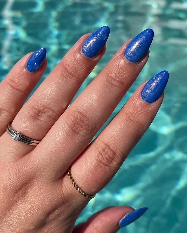 15. Shimmer Ocean Blue Almond Nails - nail ideas for vacation
