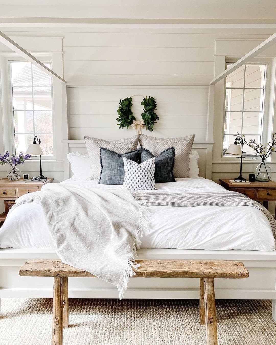 16. White Farmhouse Bedroom with Rustic Bench and Layered Pillows - white bedroom ideas