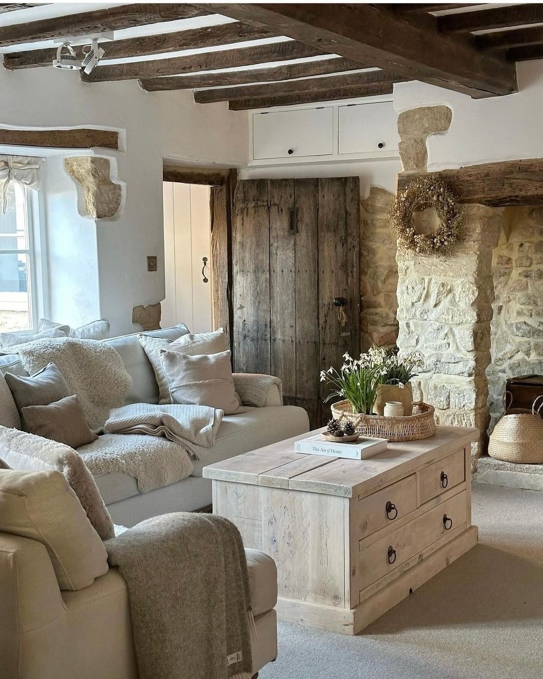 3. Rustic Stone Cottage Living Room with Warm Wood Beams - country living room ideas