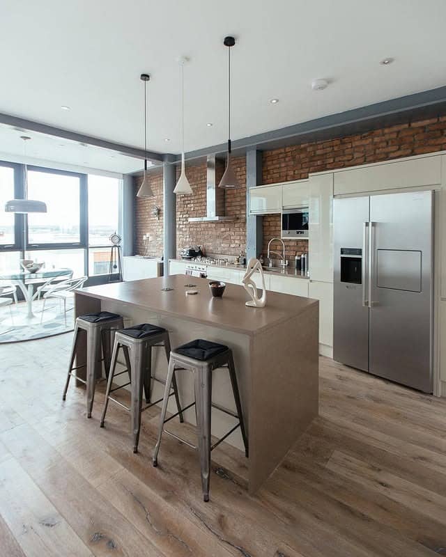 3. Loft-Style Industrial Kitchen with Brick Accent Wall and Modern Island - industrial kitchen ideas