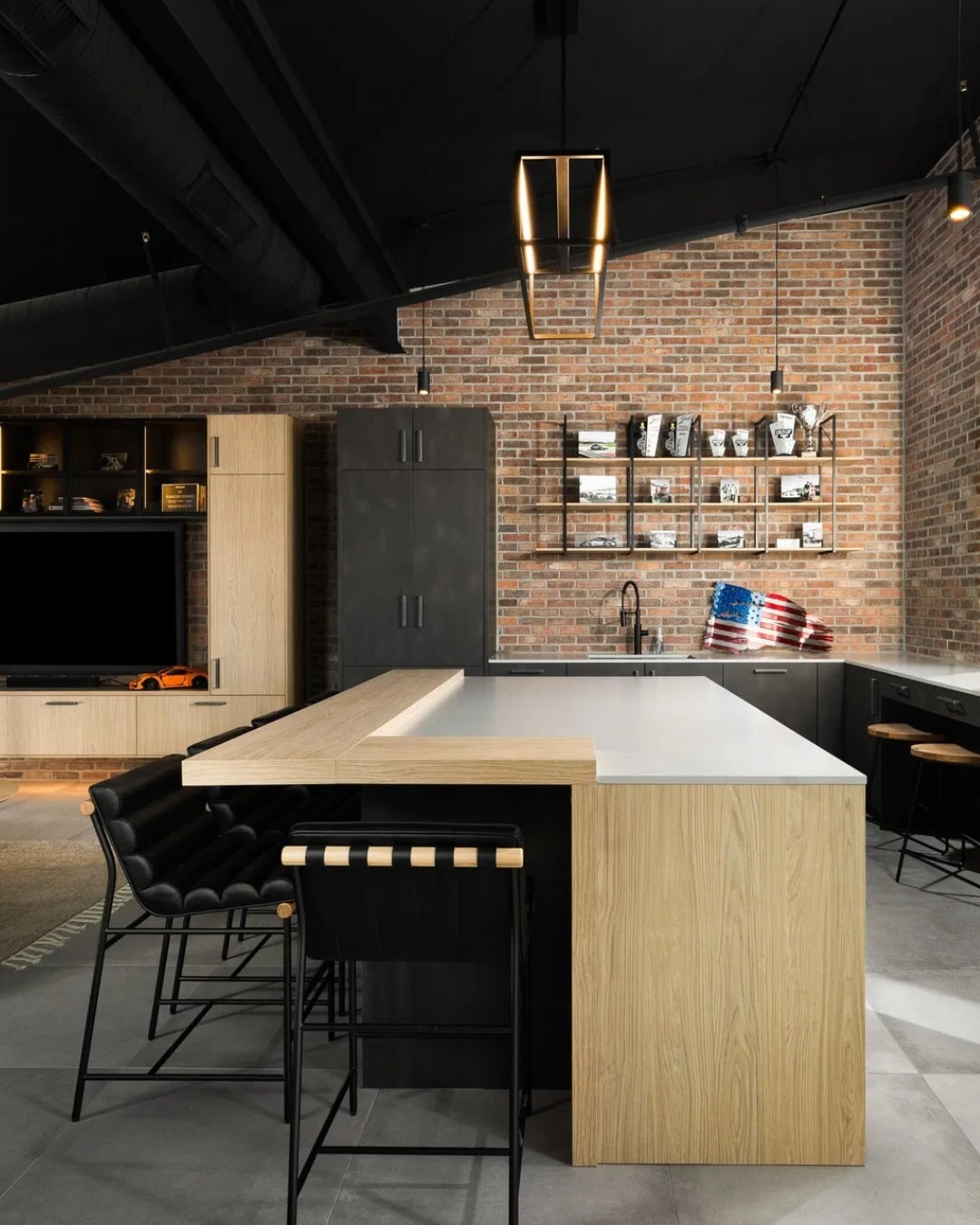 7. Brick Industrial Kitchen with Black Cabinets and Wood Island Extension - industrial kitchen ideas