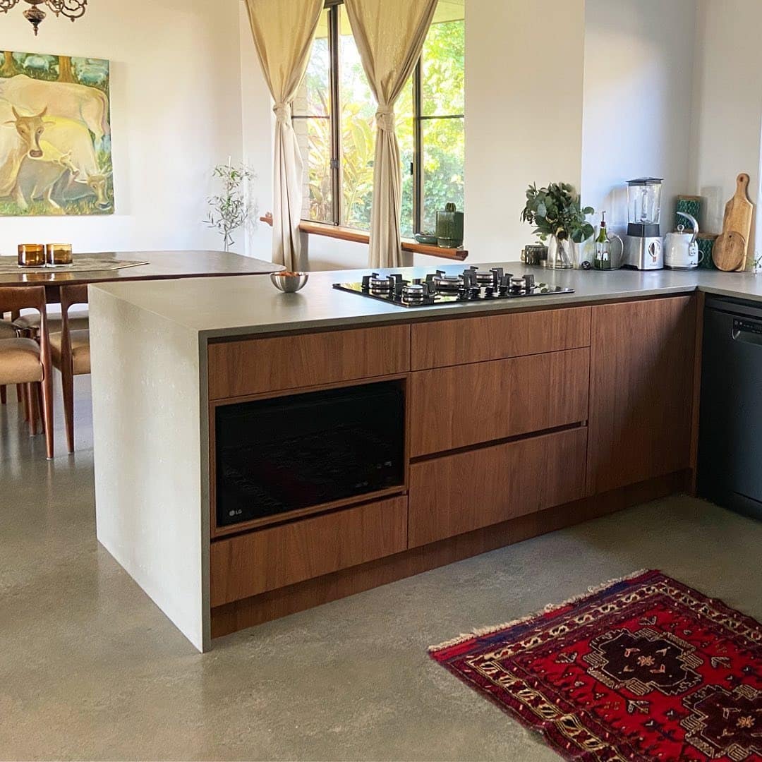 12. Mid-Century Industrial Kitchen with Walnut Cabinets and Concrete Island - industrial kitchen ideas
