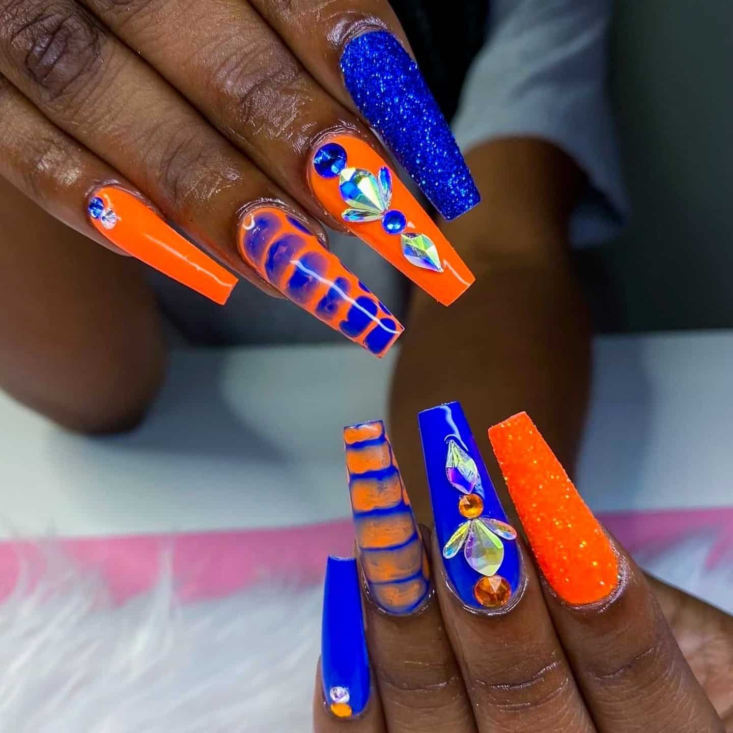 16. Long Coffin Orange and Blue Glam Nails with Crystal Embellishments - orange and blue nail ideas