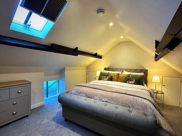 4. Cozy Attic Loft Bedroom with Warm Lighting and Skylight - loft bedroom ideas
