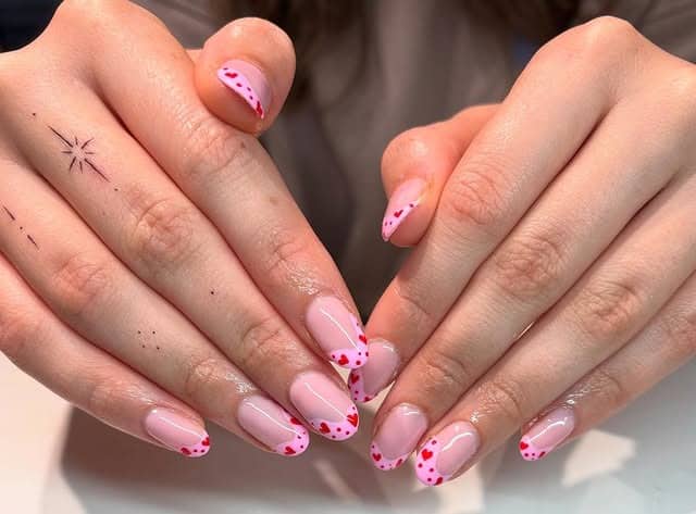 9. Sheer Pink Micro French Nails with Tiny Red Hearts - pink heart nail ideas