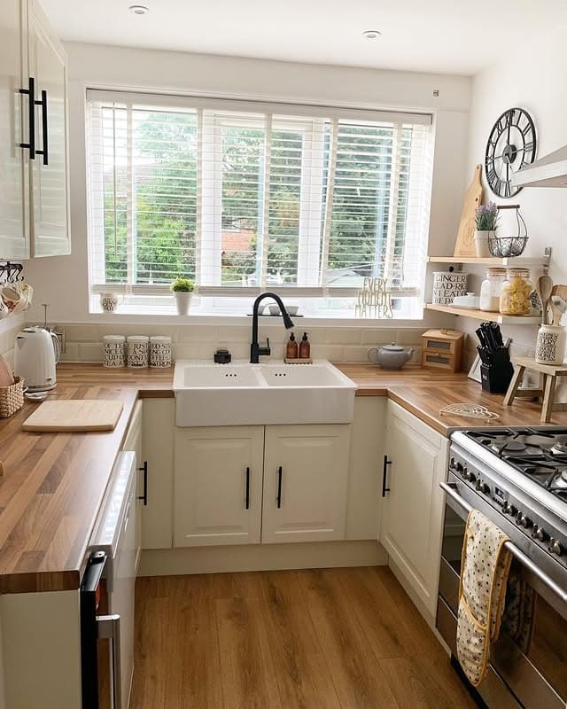 21. Bright Cream Kitchen With Farmhouse Sink and Wood Countertops - cream kitchen ideas