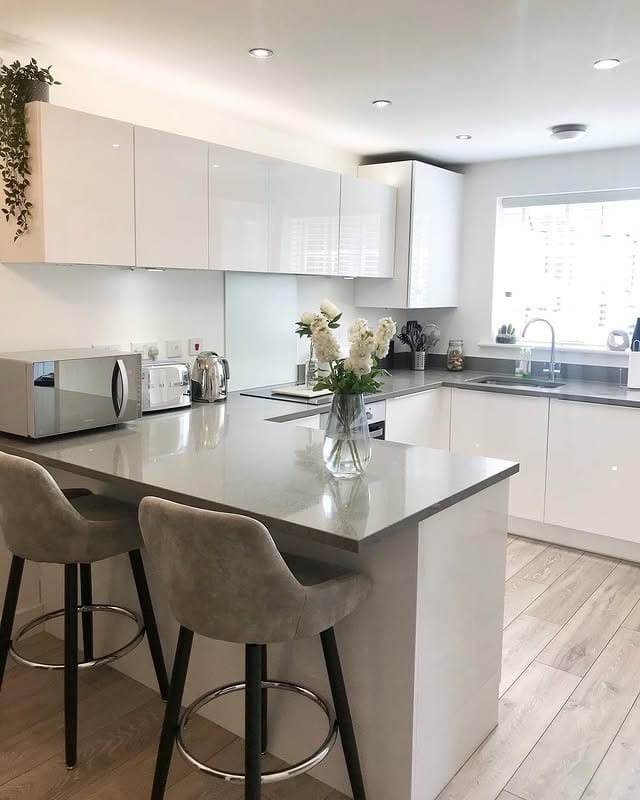 17. Bright White Kitchen with Grey Countertop Peninsula - grey and white kitchen ideas