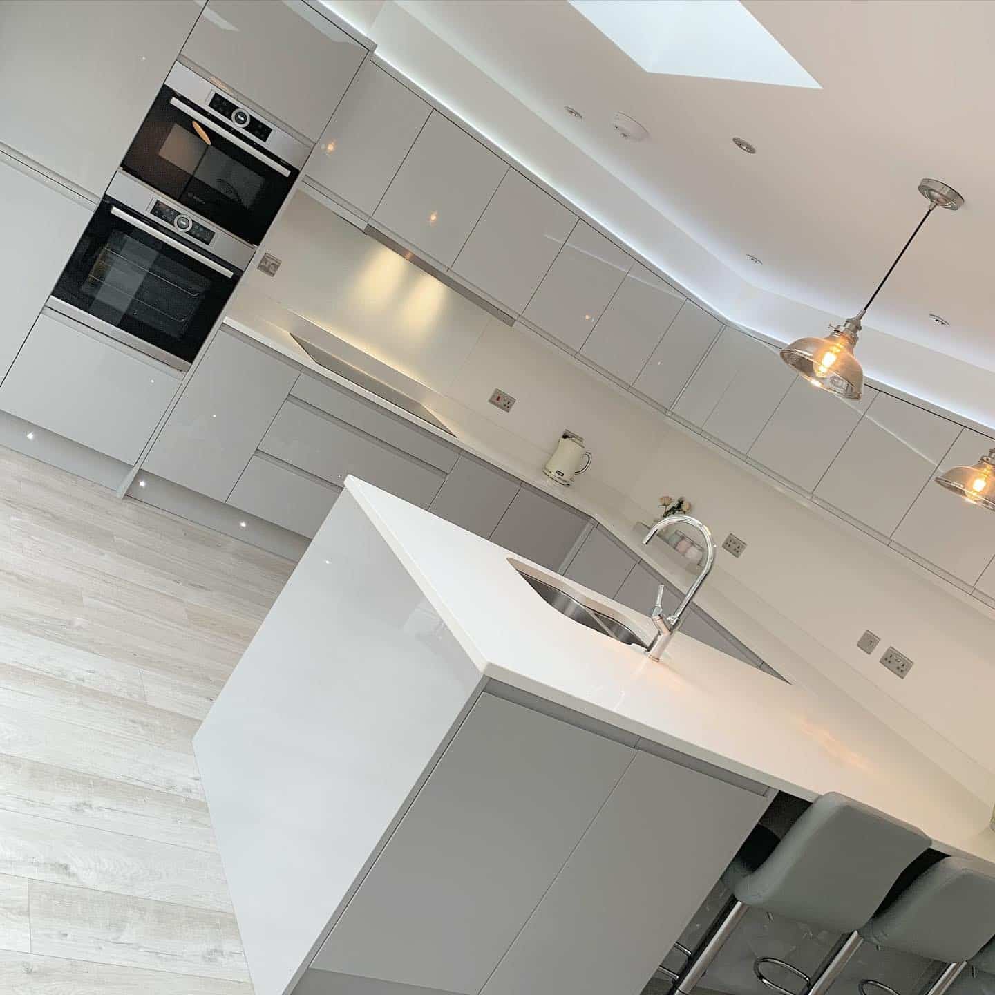 20. Modern Grey and White Island Kitchen with Integrated Lighting - grey and white kitchen ideas