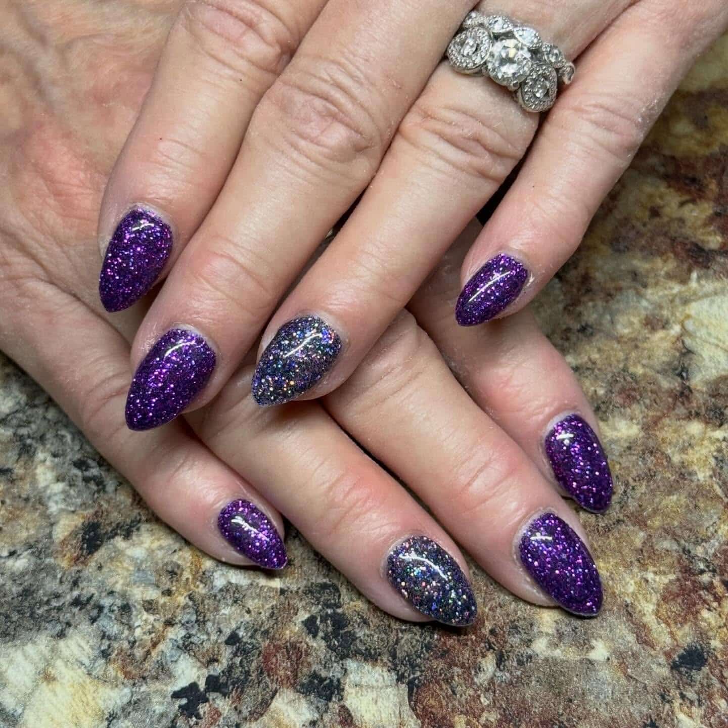 7. Deep Violet Almond Nails with Multicolor Glitter Accent - purple glitter nail ideas