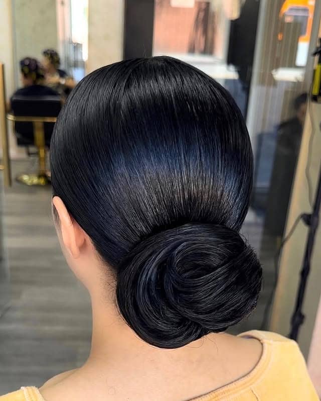 11. Sleek Low Bun with Jet Black Shine - Slick Back Hairstyles