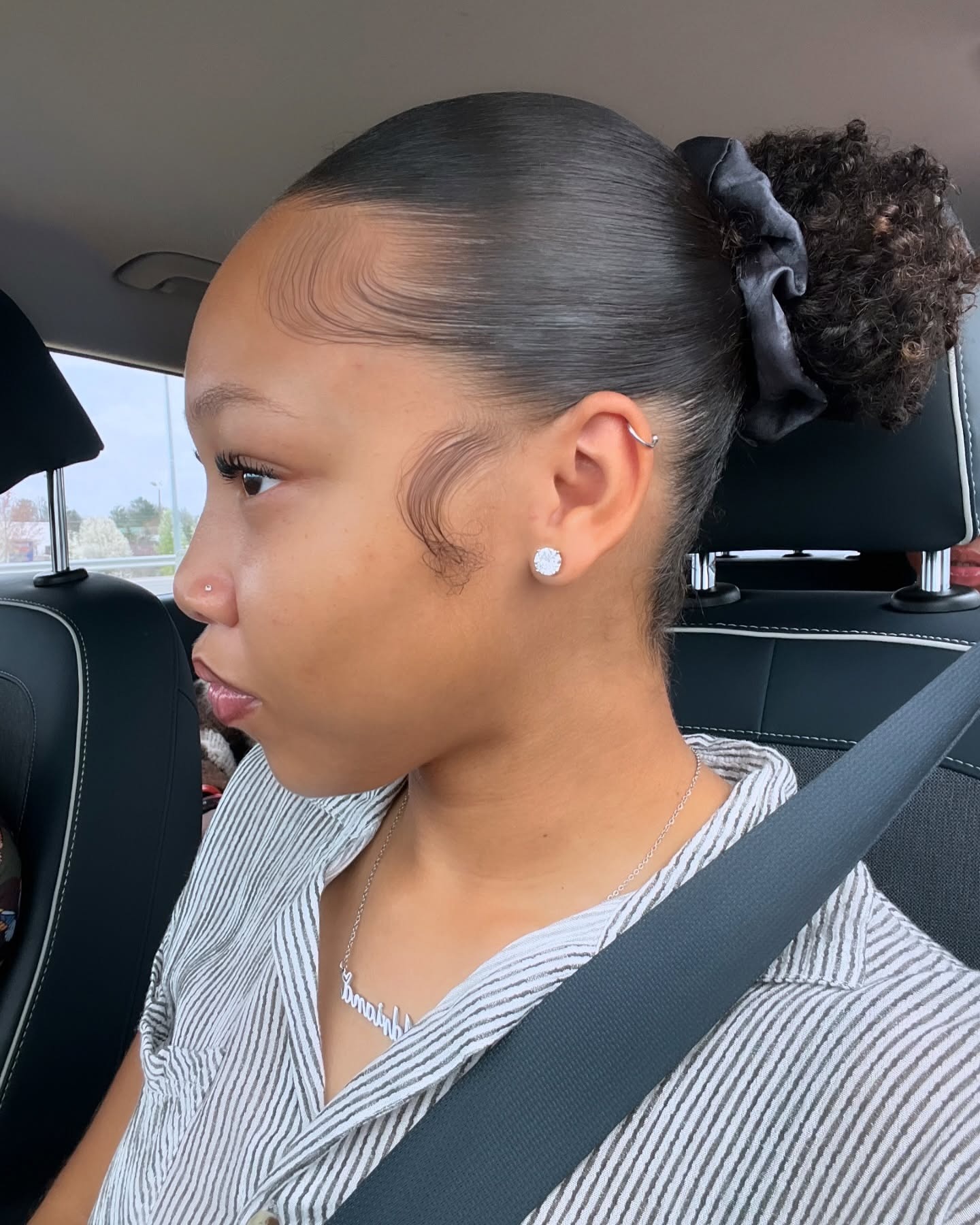 20. Sleek Curly Puff Bun with Natural Black Tone - Slick Back Hairstyles