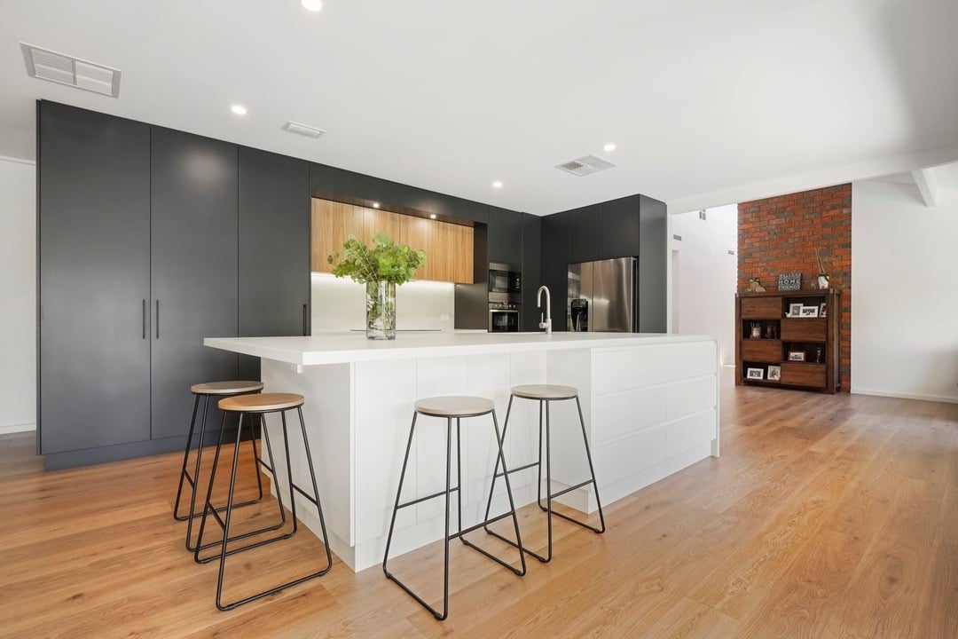 5. Minimal Black Cabinet Kitchen with Large White Island - white and black kitchen ideas